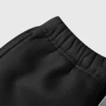 Close-up view of the adjustable drawstring waist detail on the black H-king of Hellstar tracksuit pants.
