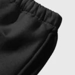Close-up view of the elastic waistband and premium fabric on the H-King of Hellstar black tracksuit pants.