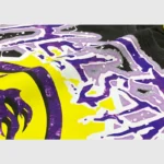 Close-up view of the unique purple and yellow graphic screen print design on the black Hellstar Amethyst T-Shirt.
