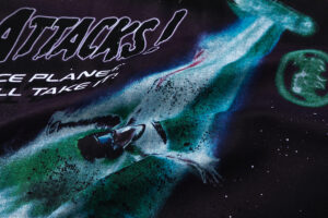 Close-up graphic detail of the Hellstar Attacks Hypnotic Vision black t-shirt featuring green space art print.