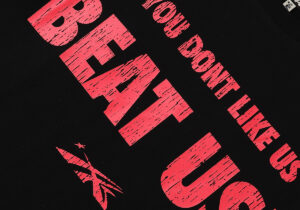 Close up view of the red and black graphic print on a Hellstar Beat Us t-shirt with distressed lettering details.