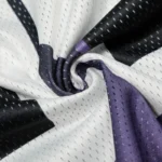 Close-up view of the Hellstar black and purple mesh patchwork fabric detail on a premium long sleeve streetwear tee.