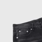 Close-up view of the Hellstar black denim flare jeans showing the classic five-pocket design and custom metal hardware.