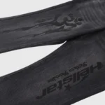 Close-up of Hellstar black denim flare jeans featuring signature streetwear graphic prints and vintage wash texture.