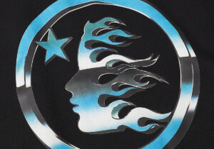 Detailed close-up of the flame and star logo graphic featured on the premium Hellstar Black Victory Capsule Hoodie.