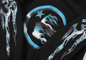 Close-up view of a Hellstar black hoodie featuring a metallic blue circular graphic with flames and star details.