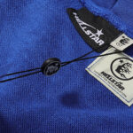 Close-up view of the Hellstar No Guts No Glory blue hoodie showing the brand's official NFC authentication tag.