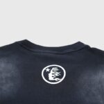 Close-up view of the back of a black Hellstar Box Logo T-shirt featuring the brand's iconic flame logo detail.
