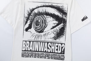 Detail of the graphic design on the white Hellstar Brainwashed t-shirt showing a large eye and descriptive text.