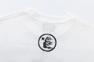 Close-up view of the branded graphic on the neck area of the white Hellstar Brainwashed T-shirt garment.