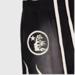 Detailed close-up of the Hellstar Capsule 8 Paradise black sweatpants featuring the iconic white graphic side logo print