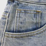 Close-up view of the vintage washed denim fabric texture and reinforced pocket stitching on Hellstar Capsule 9 shorts.