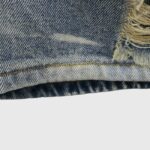 Detailed view of the frayed raw edge and vintage stone-washed texture on the Hellstar Capsule 9 denim shorts.