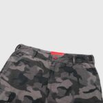 Detailed view of the Hellstar cargo shorts featuring a camouflage pattern and a distinct red logo waist detail.