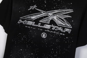Close up of the Hellstar Chrome Logo T-Shirt featuring a white space-themed graphic on a black fabric background.