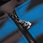 Close-up of the Hellstar Classic Logo Airbrush Zip-Up hoodie showing the custom metal flame zipper pull detail.