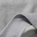 Close-up view of the premium grey heavyweight fleece fabric texture from the exclusive Hellstar x ComplexCon hoodie.