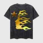 Black vintage washed Hellstar T-shirt featuring a gold graphic print of a profile face in flames and a star icon.