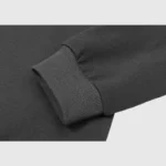 Close-up view of the premium black cotton-blend fabric and ribbed cuff on the Hellstar Crying Baby Graphic Hoodie.
