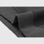 Close-up view of the premium black cotton-blend fabric, ribbed hem, and high-quality texture of the Hellstar hoodie.