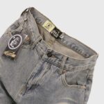 Grey denim jeans from Hellstar featuring a branded button closure, internal tag, and a logo hangtag attached to the waist.