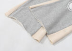 Close-up view of the raw edge hem and contrast side panels on Hellstar Enlightenment grey sweatpants fabric.