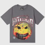 Hellstar Evil Smile gray vintage-washed T-shirt featuring a cracked yellow evil smiley face and distressed Hellstar logo