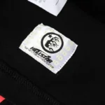 The Hellstar Family Letter Printed T-Shirt includes a branded fabric label with a built-in NFC authentication tag.