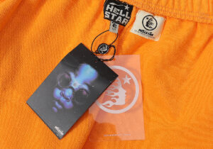 Detailed look at the Hellstar branding and authentication tags on orange fleece sweatpants from Hellstar Studios.