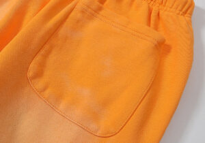 Close-up view of the back pocket detail on the vibrant Hellstar Fire Orange closed elastic bottom streetwear sweatpants.