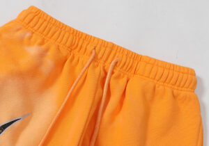 Detail view of the elastic waistband and adjustable drawstring on Hellstar Fire Orange sweatpants.