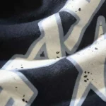 Close-up view of the bold graphic screen print on Hellstar Fire elastic sweatpants in premium black fabric.