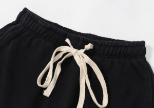 Close-up view of the adjustable elastic waistband and cream drawstring on Hellstar Flame Flare black sweatpants.