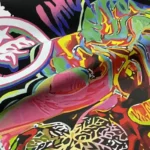 Close-up fabric detail of the Hellstar Fun Color Brain graphic print on a vintage washed black cotton T-shirt.
