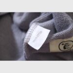 Close-up view of the 100% cotton fabric tag and Hellstar brand logo inside the Future Flame streetwear hoodie.