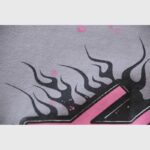 Close up of the grey fabric of a Hellstar Future Flame hoodie featuring black and pink graphic flame details.