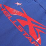 Close-up view of the bold red gel logo print on a blue Hellstar tracksuit fabric designed for casual or athletic wear.