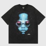 Hellstar Goggles T‑Shirt black cotton tee with vibrant blue sci‑fi face graphic and oversized pink goggles, Hellstar logo