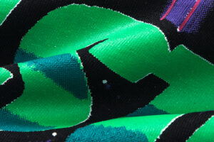 Close-up view of the vibrant green and black graphic print detail on the Hellstar Goggles T-Shirt fabric texture.