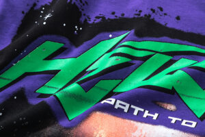 Close up of the vibrant green graphic and logo detail featured on the front of the purple Hellstar Goggles T-Shirt.