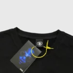 Close-up view of the Hellstar Gradient Flame T-shirt neck tag and branded clothing label with a yellow security seal.