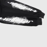 Close-up of the black Hellstar hoodie sleeve featuring a white graffiti print logo on cotton-blend fleece fabric.