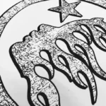 Close-up of the distressed graffiti graphic print on a Hellstar streetwear cotton T-shirt featuring a star emblem.