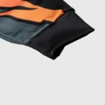 Detail of the cuff on a grey and orange Hellstar mesh long sleeve tee, showcasing the performance fabric texture.