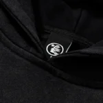 Close-up view of the interior neck label on the premium black Hellstar Groovy cotton hoodie for branding verification.