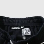 Close-up view of the interior tag and branding details on a black Hellstar Guts Glory tracksuit item.