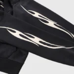 Black Hellstar hoodie sleeve featuring a signature white graphic print design with stylized flame-like details