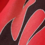 Close-up view of the vibrant flame graphic print on the premium red cotton-poly fabric of Hellstar Halloween sweatpants.