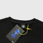 Close-up view of the black Hellstar Hand Prayer t-shirt featuring the branded neck tag and attached yellow security tag.