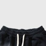 Close-up view of the elastic waistband and white drawstring detail on black Hellstar Heaven Sounds summer shorts.